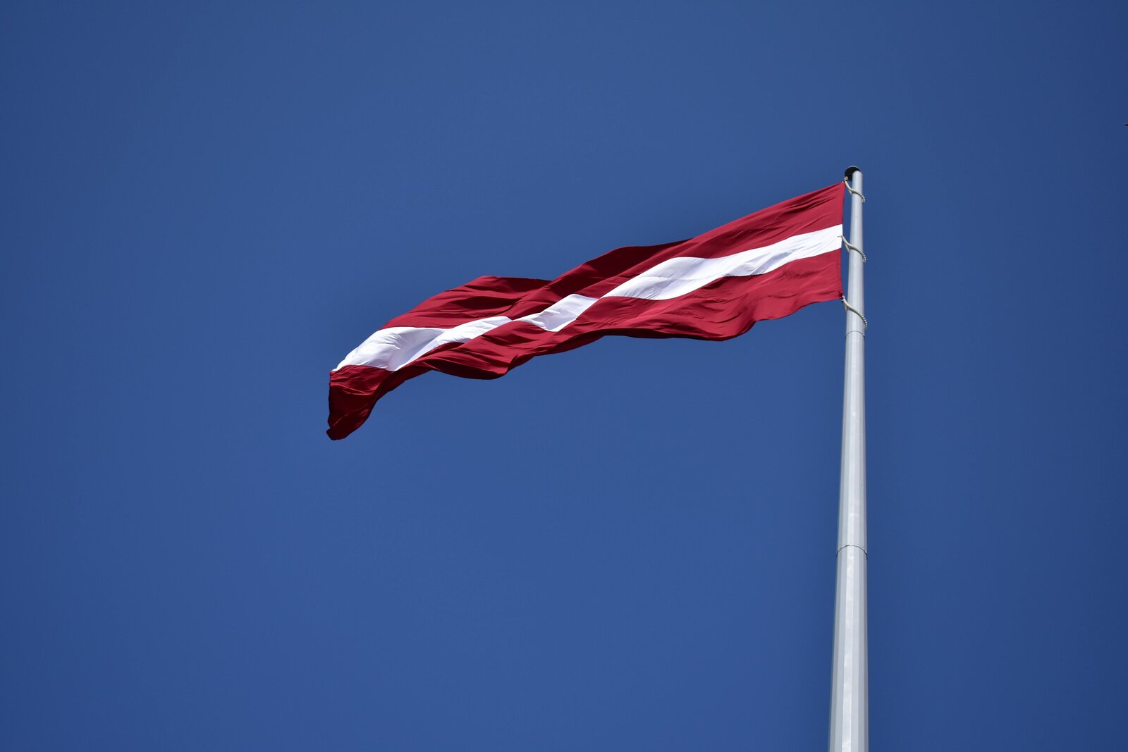 The Latvian flag against a blue sky