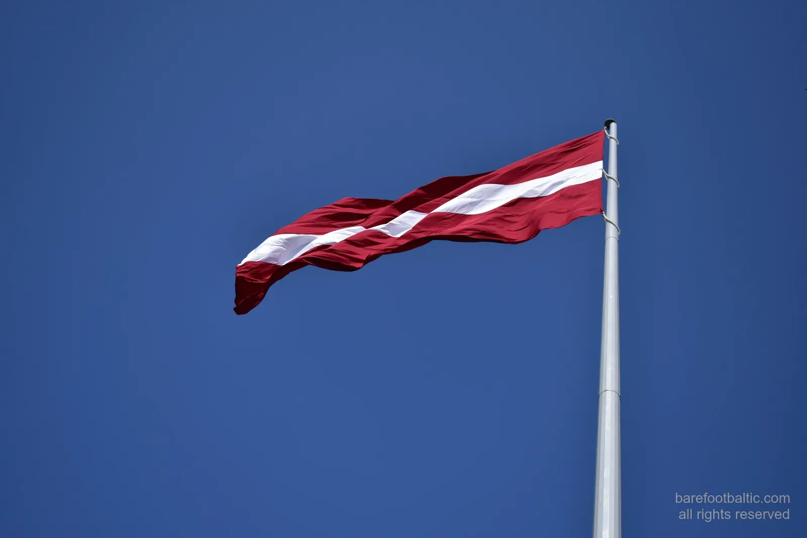 The Latvian flag against a blue sky