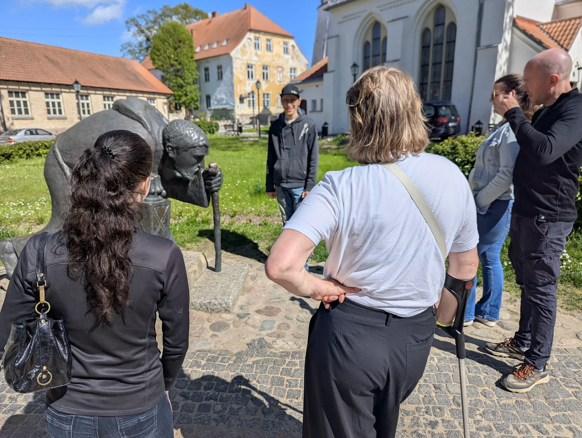 Tour group around the bronze pilgrim sculpture in Cēsis old town