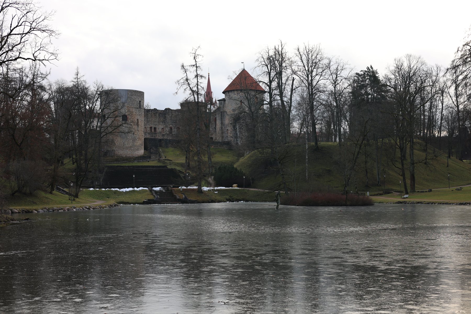 Cēsis Castle reflected in a winter pond with bare trees