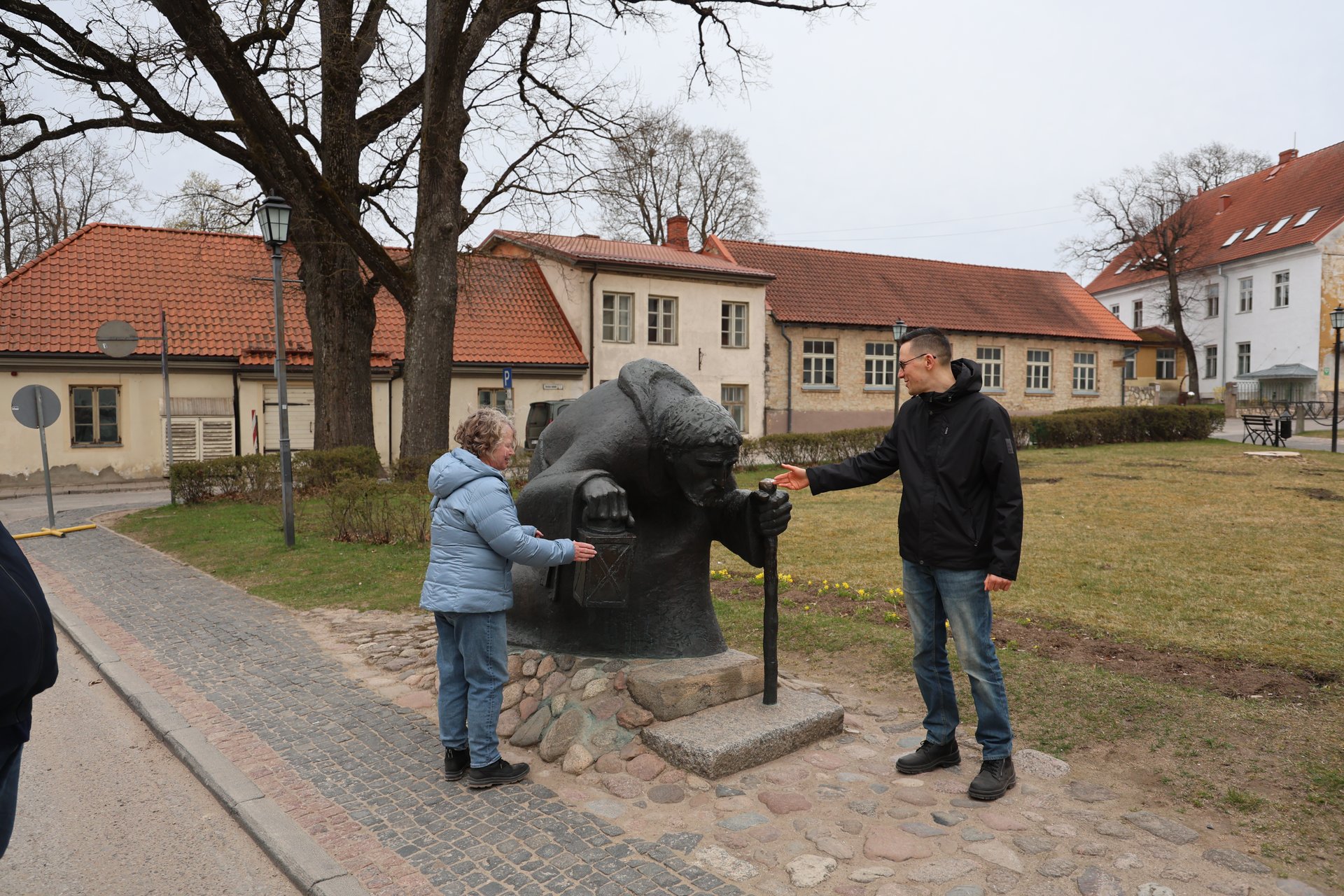 Tour group at the bronze pilgrim sculpture in Cēsis old town park