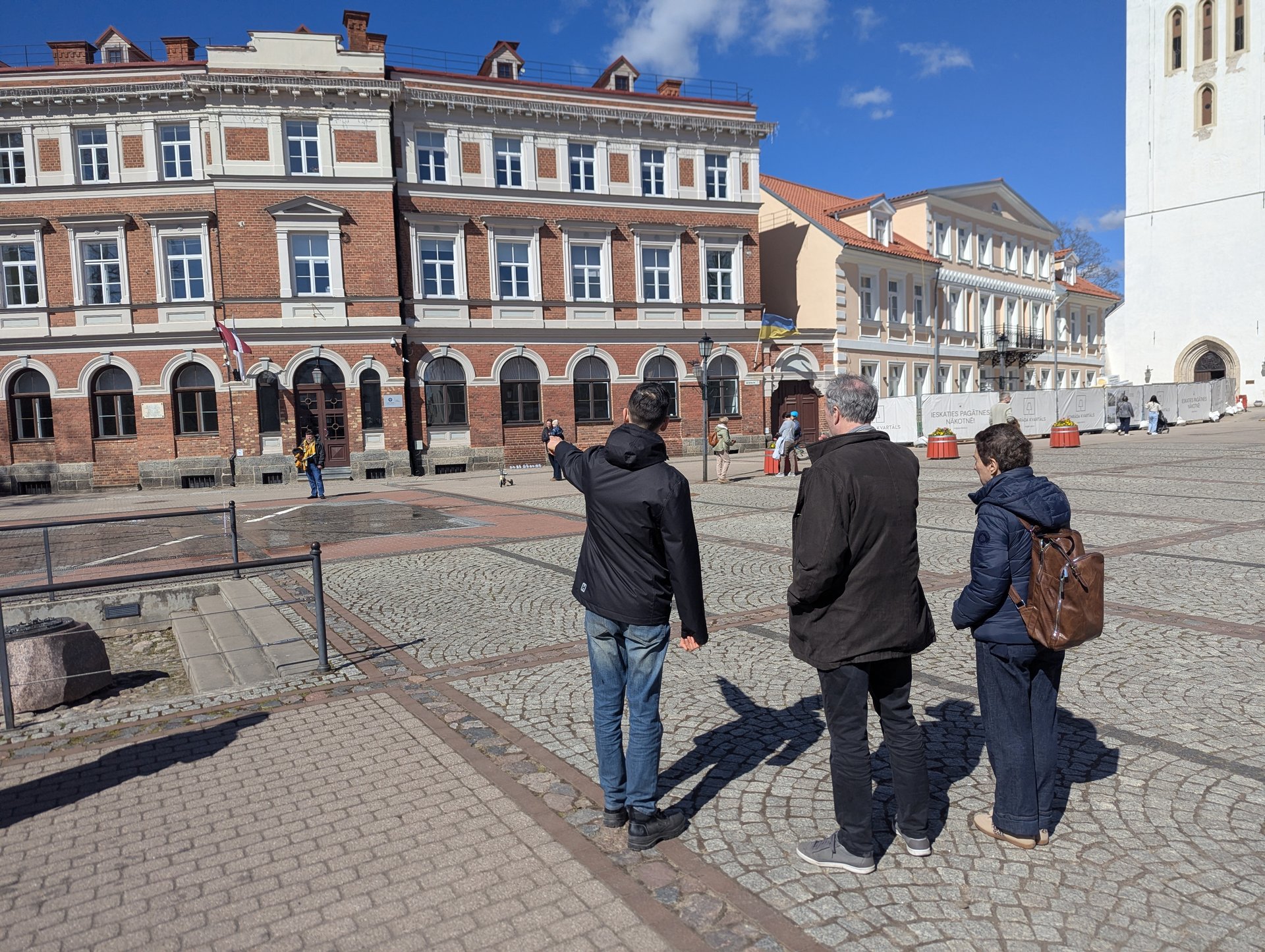 Cēsis old-town walking tour, guide pointing out a heritage building