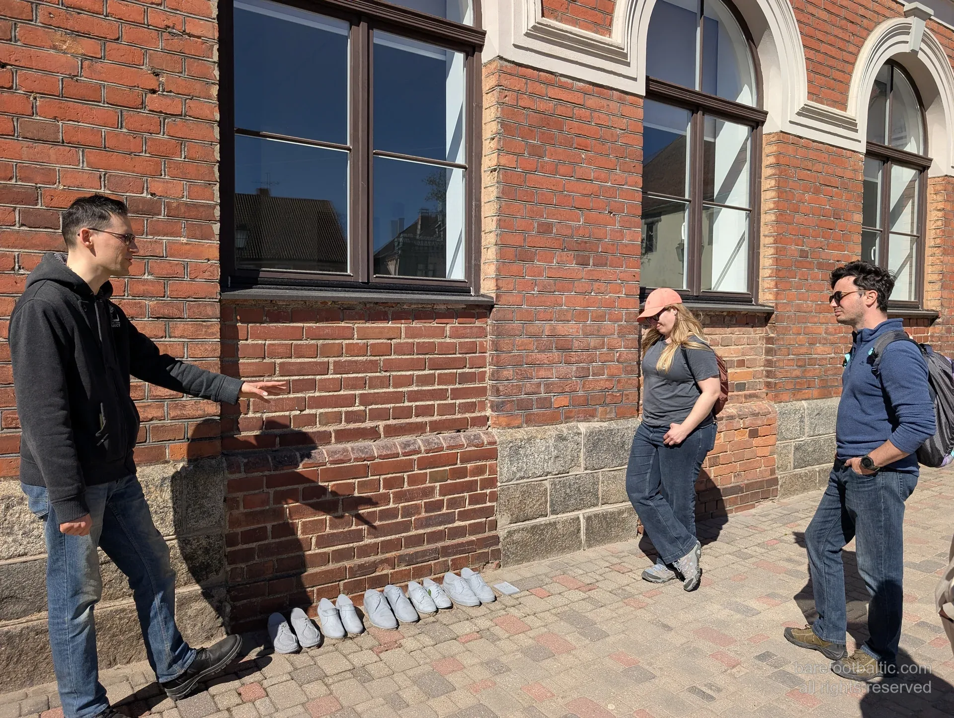 Guide pointing out wall details on the Cēsis old-town walking tour