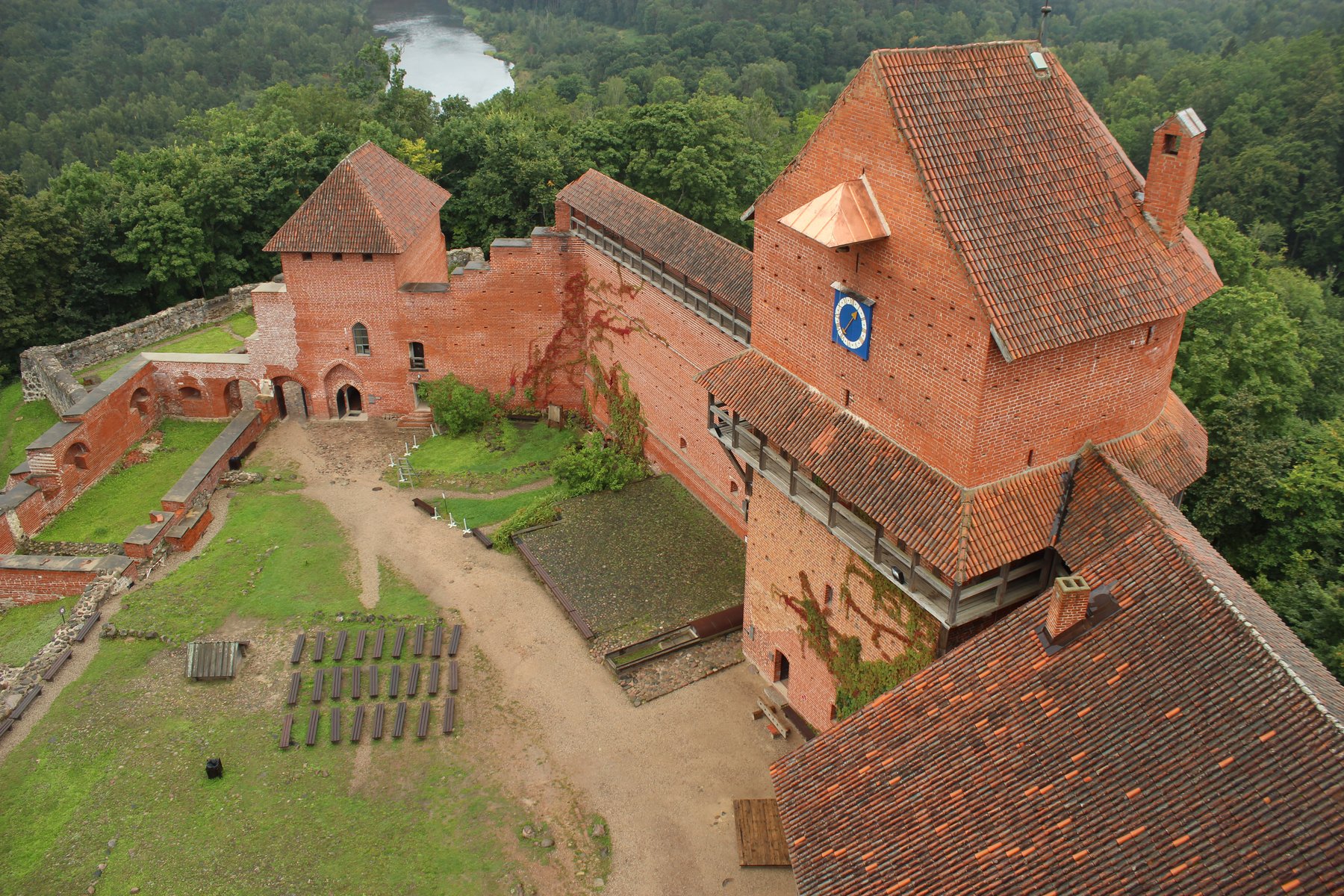 Aerial view of Turaida Castle's red-brick walls and tower above the Gauja Valley