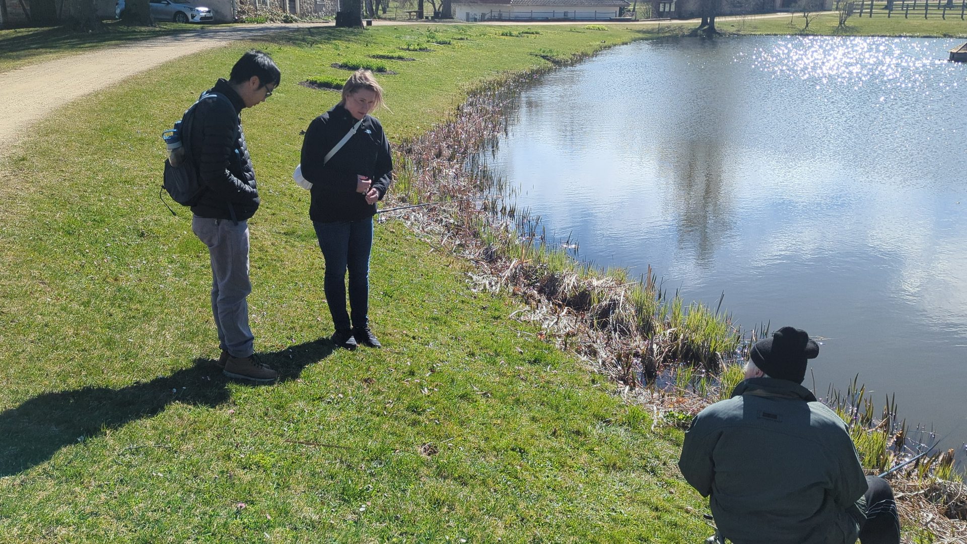 Visitors inside the Turaida Castle complex by the pond